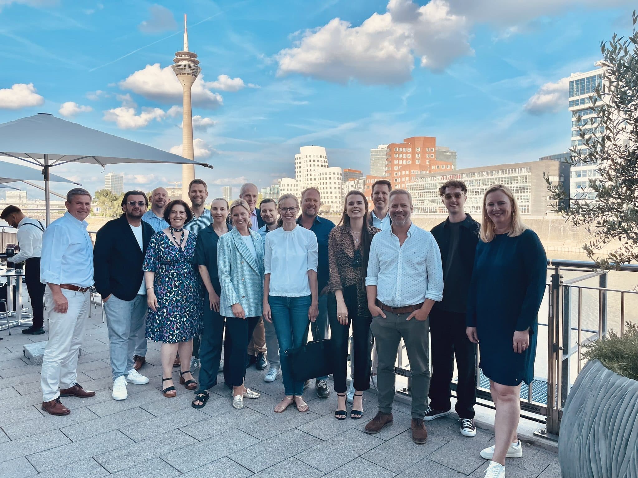 Teilnehmende einer Staffel auf einer Terrasse im Düsseldorfer Medienhafen
