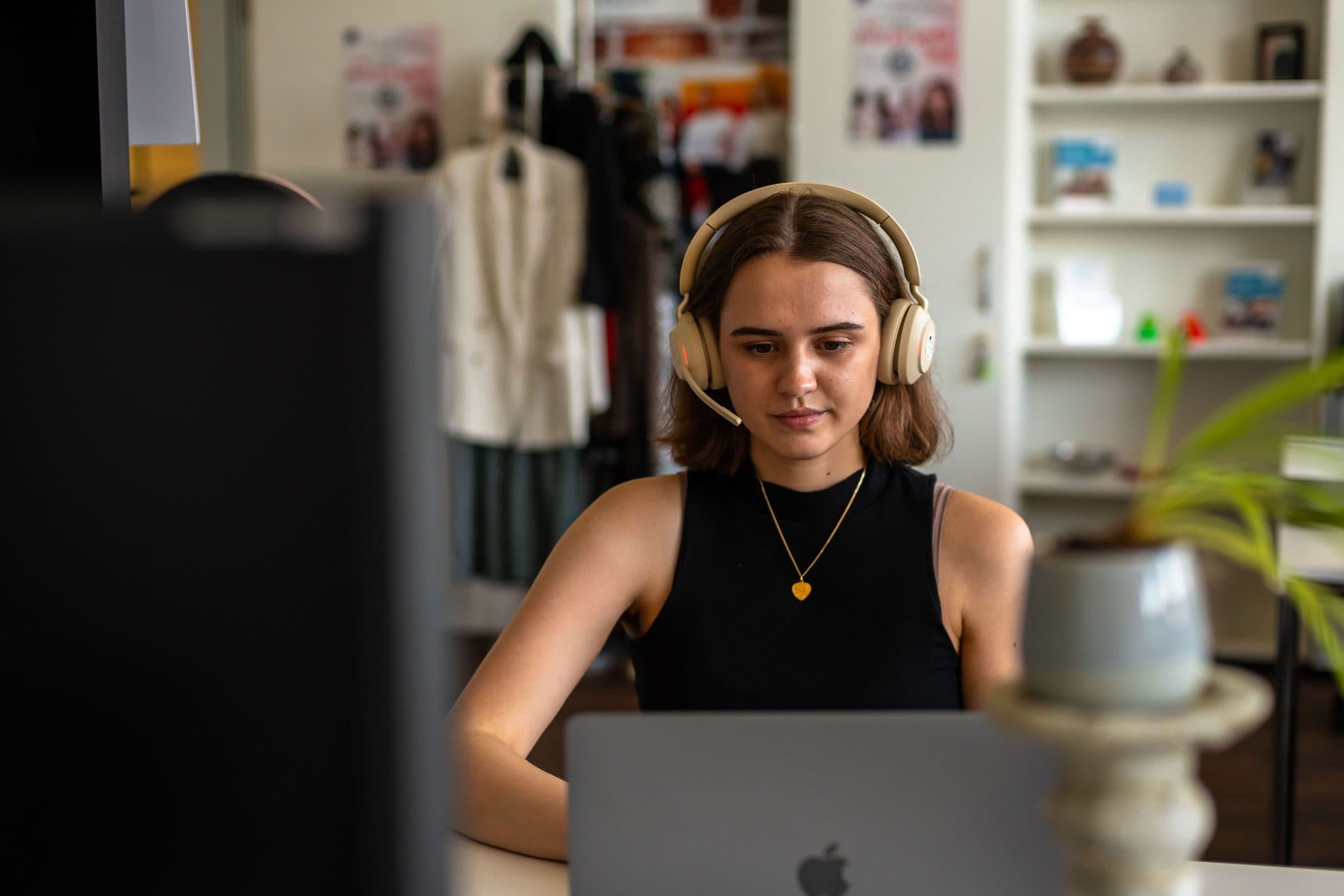 Teilnehmerin mit Headset vor dem Laptop während einer Live-Session