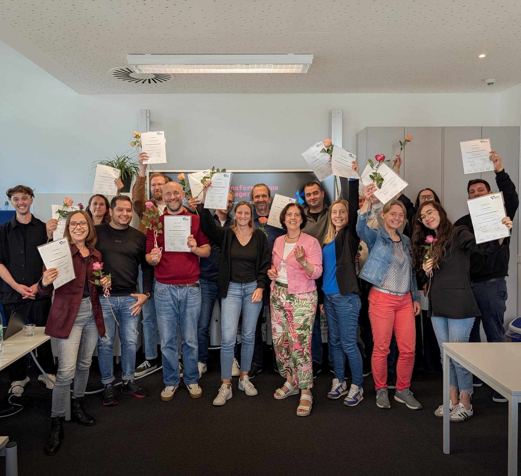 Gruppe von Absolventinnen und Absolventen hält ihre Zertifikate hoch